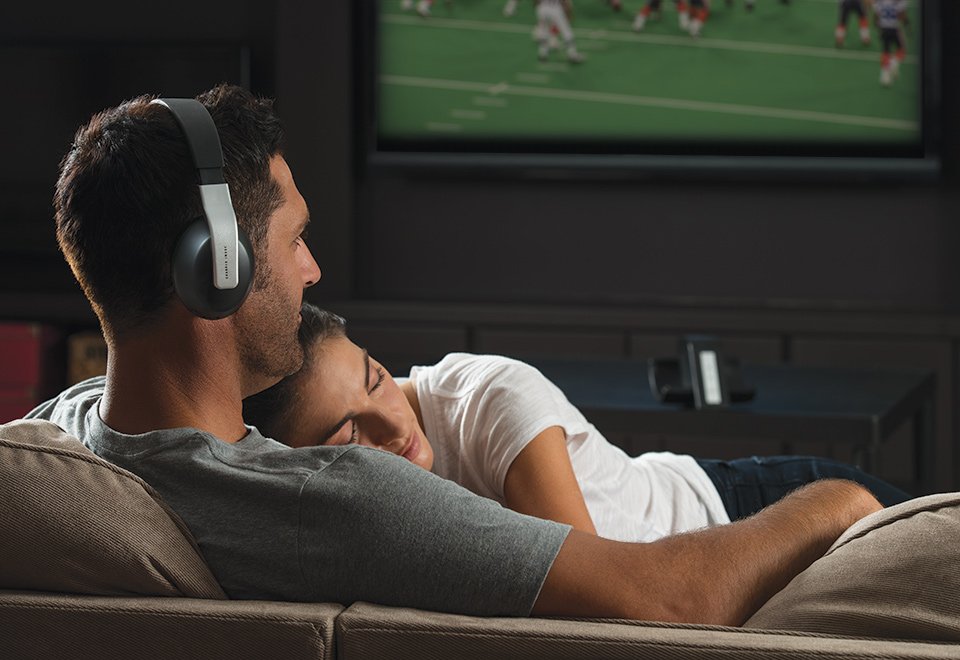 Image of a man use Headphones on his TV